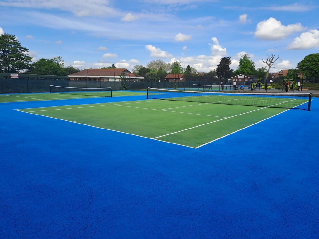 Wide shot of fresh acrylic tennis court in Redbridge